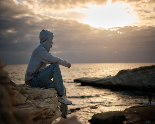 Man walking comfortably by the sea in Limassol during sunset